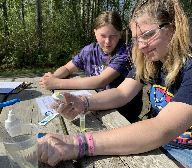 Two young students doing water sample testing.