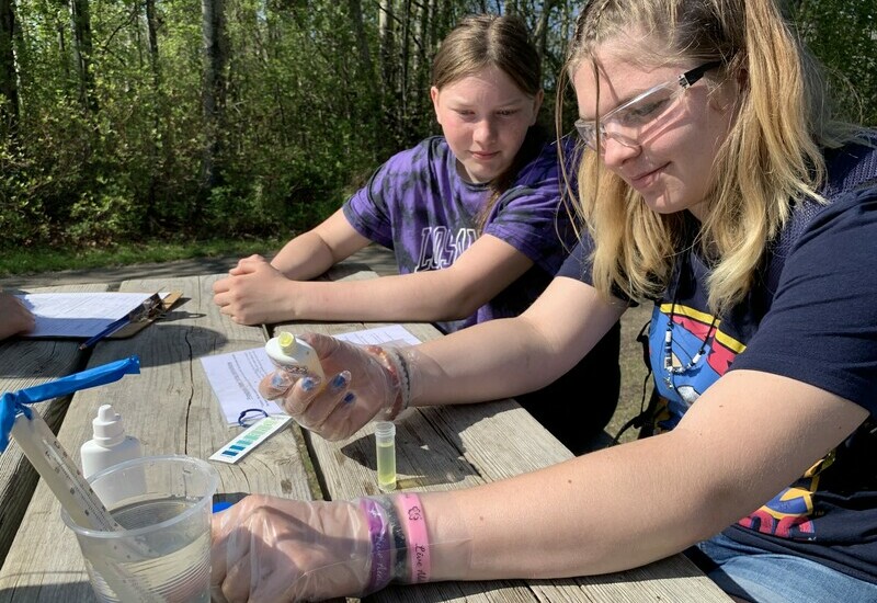 Two young students doing water sample testing.